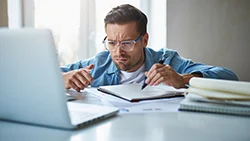 Мужчина задумчиво смотрит в монитор ноутбука